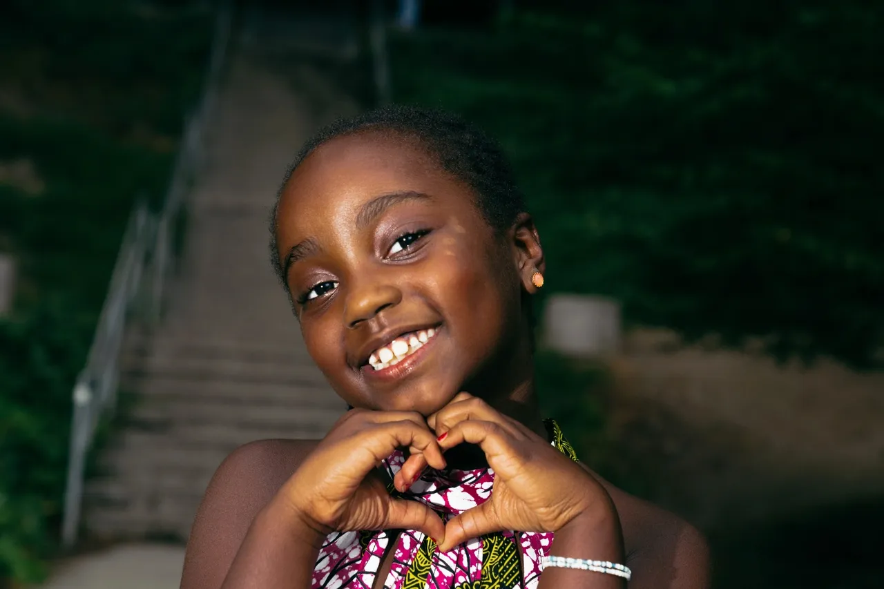 Girl smiling and making a heart with her hands